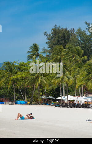 Mann liest Buch über Cenang Beach, Langkawi, Malaysia Stockfoto