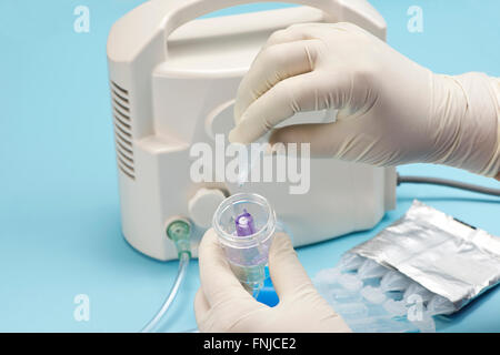 Krankenschwester Füllungen Medikamentenbehälter mit Salbutamol Sulfat für Inhalationstherapie mit medizinischer Vernebler. Albuterol ist eine gemeinsame medicatio Stockfoto