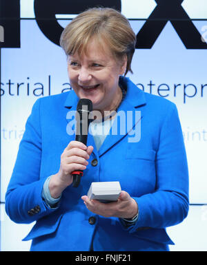 Hannover, Deutschland. 15. März 2016. Bundeskanzlerin Angela Merkel versucht ein Produkt von Schweizer Unternehmen Nexiot bei ihrem Besuch auf der CeBIT 2016 in Hannover, Mitteldeutschland, am 15. März 2016. Die Schweiz ist Partnerland der CeBIT 2016. Bildnachweis: Luo Huanhuan/Xinhua/Alamy Live-Nachrichten Stockfoto