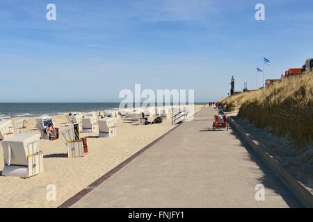 Ein Fußweg auf der Insel Wangerooge zwischen dem hellen Strand voller Liegestühle und ein Dünengürtel, 20. April 2015 Stockfoto