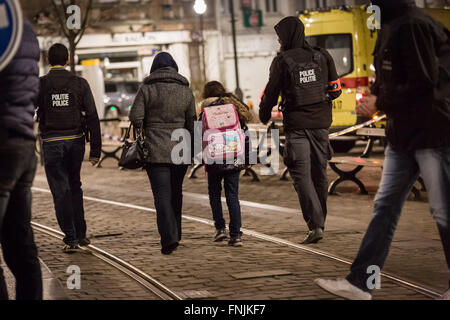 Brüssel, Belgien. 15. März 2016. Ein Offizier nimmt Menschen wieder nach Hause nach so dass einige Leute in ihre Häuser zurückkehren. Brüsseler Beamte bestätigten eine große Operation wurde im Gange mit Polizei untersucht den 13 November Shootings, wenn mindestens ein Schütze das Feuer eröffnet, allerdings berichteten lokale Medien die Menschenjagd, die folgten, als mit zwei Verdächtige. Bildnachweis: Aurore Belot/Pacific Press/Alamy Live-Nachrichten Stockfoto