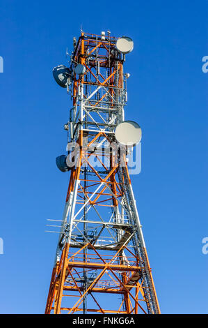 Radio/Fernmeldeturm in weiß und Orange mit blauem Himmel Stockfoto