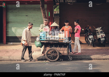 Frau verkaufen Essen auf der Straße in Sigon Vietnam - Nudelsuppe Pho - vietnamesisches Frühstück Stockfoto