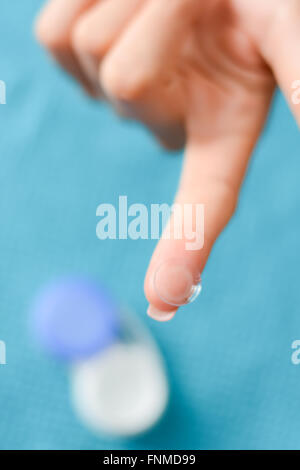 Weiche Kontaktlinse auf einer Frau Fingerspitze, mit offener Fall im Hintergrund Stockfoto