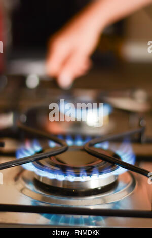 Frau einen Gas-Herd einschalten Stockfoto