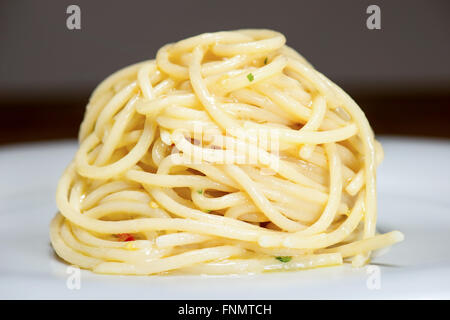 Spaghetti mit Knoblauch, Öl und Peperoni mit Petersilie und Gabel am Tisch Stockfoto