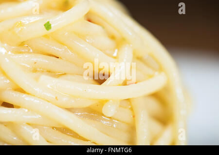 Spaghetti mit Knoblauch, Öl und Peperoni mit Petersilie und Gabel am Tisch Stockfoto