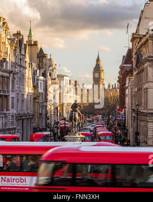 Ein Sonnenuntergang erfasst Form Trafalgar Square mit Blick auf Elizabeth Tower, über eine Straße voll von Bus, London, England. Stockfoto