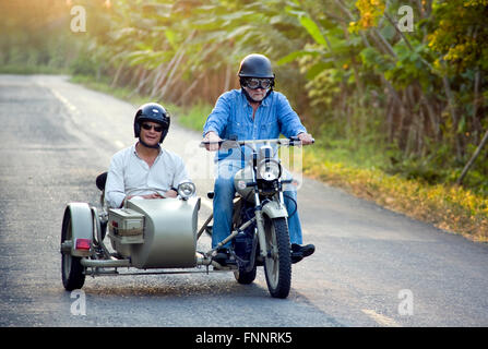 Präsident Rafael Correa und Showmaster Peter Greenberg fahren einen Oldtimer Motorrad mit Beiwagen in der Kakao-Region während der Dreharbeiten von Ecuador: The Royal Tour. Stockfoto