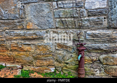Alte rostige Wasser Wasserhahn auf Seite des Gebäudes Stockfoto