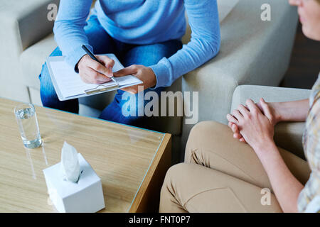 Männliche Psychologe Notizen während der psychologischen Therapie Stockfoto