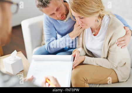 Weinende Frau besuchenden Psychologen mit ihrem Ehemann Stockfoto