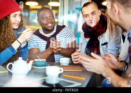 Gruppe von Freunden diskutieren gemeinsam am Tisch Stockfoto