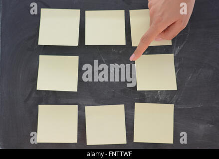 Frau Hand Entsendung leere Klebstoffe Notizen auf Tafel Stockfoto