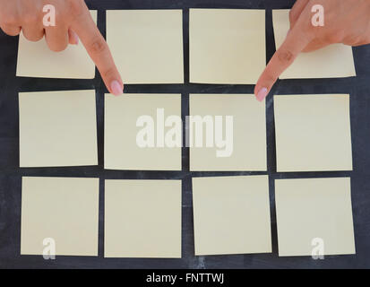 Frau Hand Entsendung leere Klebstoffe Notizen auf Tafel Stockfoto