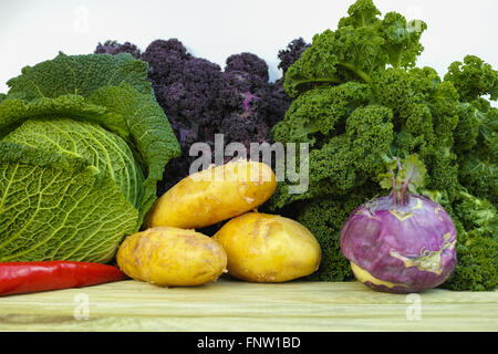 Frisches Bio-Gemüse - grün Savoy Cabbage, lila und grün Grünkohl, Kartoffeln, violette Kohlrabi auf weißem Hintergrund Stockfoto