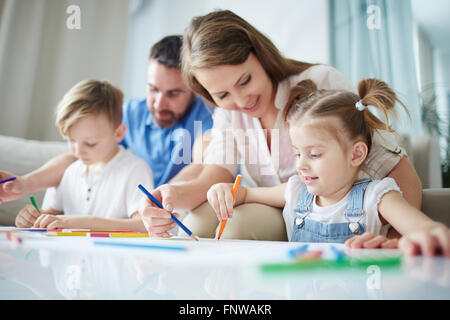 Mutter hilft ihrer kleinen Tochter zu zeichnen Stockfoto