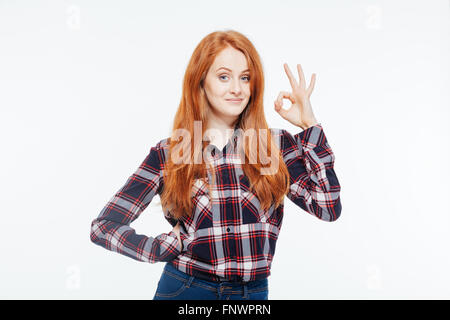 Glücklich rothaarige Frau zeigt ok Zeichen mit den Fingern auf einem weißen Hintergrund isoliert Stockfoto