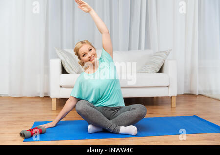 Frau macht Yoga Meditation in Lotus Pose auf Matte Stockfoto