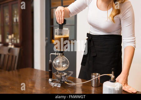 Nahaufnahme von Frau mit Siphon Kaffeemaschine Shop Stockfoto