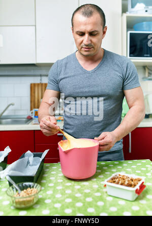 Mann allein zu Hause eine Kuchen-Rezept kochen Stockfoto