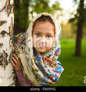 schöne Mädchen in einen Schal in einem Baum im park Stockfoto