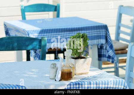 Typisch griechisch oder Türkisch Taverner Restaurant mit Tischen im Garten blau-weißen Tuch gemalt Stühle roten Geranien Stockfoto