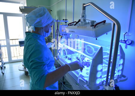Eine Krankenschwester im Krankenhaus in der Nähe des Inkubators, in dem ein neugeborenes Baby liegt. Stockfoto