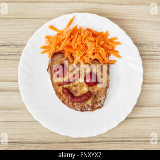 Lustiges Gesicht aus Brot, Karotte, Chili, Tomaten und Ketchup. Humorvolle Essen. Kleine Prinz. Stockfoto