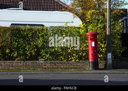 Straßenszene mit Hecke und roten Briefkasten in Swindon, Großbritannien. Stockfoto