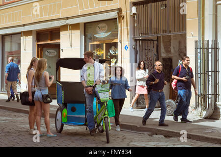 TALLINN, Estland - YUNI 12, 2015: Rikscha nimmt Touristen die Sehenswürdigkeiten der mittelalterlichen Stadt. Beliebte touristische Straße Stockfoto