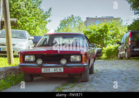 Tallinn, Estland - Yuni 12, 2015: Rote Oldtimer Ford Taunus auf Pflaster in einer verlassenen Straße geparkt. Sonnigen Sommertag. Tallinn Stockfoto