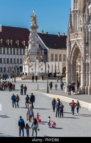 Budapest, Ungarn - 14. März 2016: Touristen auf Säule der Heiligen Dreifaltigkeit und die Matthiaskirche in Budapest, Ungarn Stockfoto