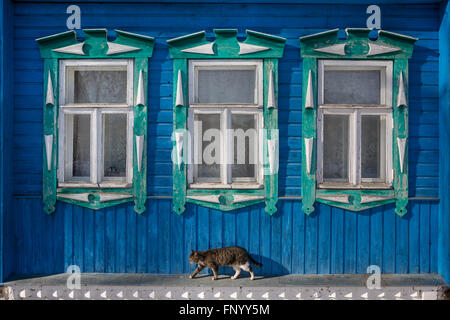 Windows mit geschnitzten Verkleidungsbretter auf das blaue alte Holzhaus Stockfoto
