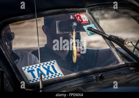 Havanna, Kuba. 16. März 2016. Ein Taxifahrer fährt mit seinem Auto, dekoriert mit einer US-Flagge in Havanna, Kuba, am 16. März 2016. US-Präsident Barack Obama geplanten Besuch in Kuba am 21. und 22. März macht ihn den ersten Präsident der USA sitzen in 88 Jahren, dies zu tun. © Joaquin Hernandez/Xinhua/Alamy Live-Nachrichten Stockfoto