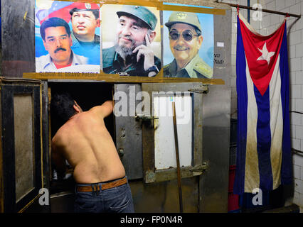 Havanna, Kuba. 16. März 2016. Ein Mann arbeitet in seinem Geschäft dekoriert mit Porträts von Nicolas Maduro, kubanischen Nationalflagge, im Zentrum von Havanna, Kuba, und Raul Castro, Hugo Chavez und Fidel Castro 16. März 2016. Kuba wird US-Präsident Barack Obama sowie Rockband Rolling Stones nächste Woche Gastgeber. © Roman Vondrous/CTK Foto/Alamy Live-Nachrichten Stockfoto