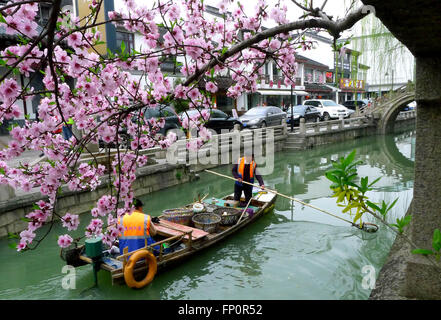 Suzhou, China Jiangsu Provinz. 17. März 2016. Zwei Sanitation Arbeiter Reinigen des Lindun-Flusses unter Pfirsichblüte in Suzhou, der ostchinesischen Provinz Jiangsu, 17. März 2016. © Wang Jianzhong/Xinhua/Alamy Live-Nachrichten Stockfoto