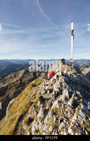 Wanderer auf dem Gipfel des Mount Hochplatte beobachten das Panorama der Ammergauer Alpen und Tirol an einem sonnigen Herbstmorgen Stockfoto