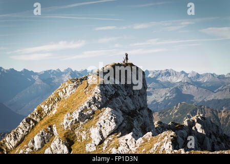 Wanderer auf dem Gipfelgrat des Mount Hochplatte unter ein Selbstporträt mit dem Alpenpanorama an einem sonnigen Herbstmorgen Stockfoto