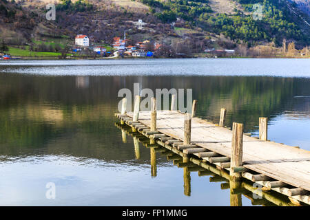 Holzsteg am Cubuk See und Dorf Hintergrund Berghang. Cubuk See in der Nähe von Göynük Provinz in der Türkei Bolu. Stockfoto