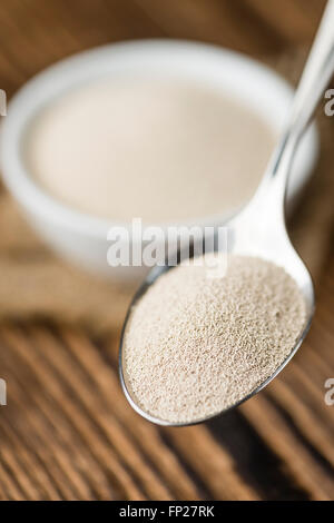 Schale mit Trockenhefe (Tiefenschärfe) auf hölzernen Hintergrund Stockfoto