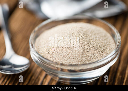 Schale mit Trockenhefe (Tiefenschärfe) auf hölzernen Hintergrund Stockfoto