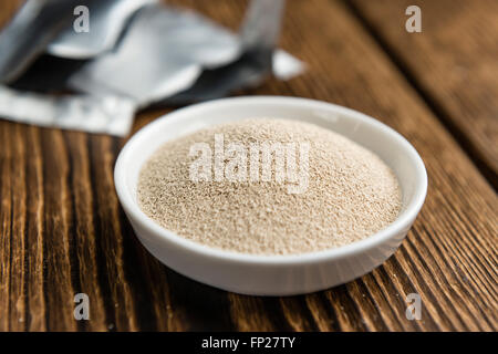 Schale mit Trockenhefe (Tiefenschärfe) auf hölzernen Hintergrund Stockfoto