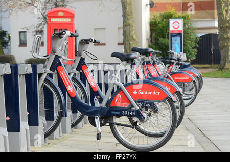 Santander ist in London mit dem öffentlichen Fahrradverleih an der Docking-Station unterwegs. Die Fahrräder des Programms sind im Volksmund als Boris Bikes bekannt Stockfoto