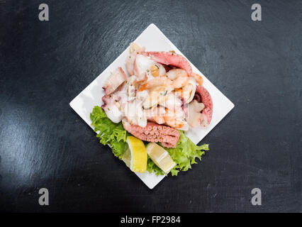 Portion Salat von Meeresfrüchten (Nahaufnahme) mit Tintenfisch, Muscheln und Garnelen Stockfoto