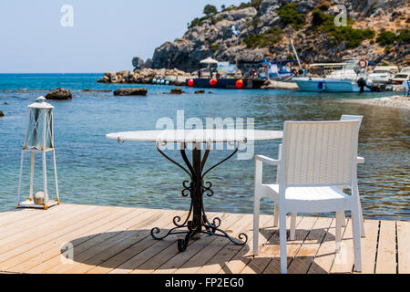 Tische mit Stühlen auf traditionelle griechische Taverne in Kolympia Stadt an der Küste von Rhodos, Griechenland. Stockfoto