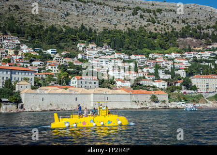 Halb-u-Boot-Touristenboot in Stadt Dubrovnik, Kroatien. Lazareti aufbauend auf Hintergrund Stockfoto