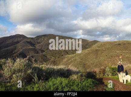 Wanderer und Hund unterwegs im Zuma Canyon Ridge-Canyon Zugang Stockfoto