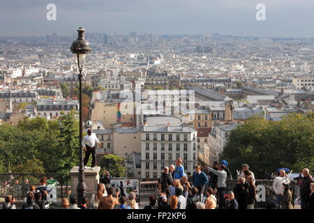 akrobatische Performance-Künstlerin in einem alten Gaslampe auf die Hügel von Sacre Coeur in Montmartre Paris Stockfoto