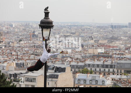 akrobatische Performance-Künstlerin in einem alten Gaslampe auf die Hügel von Sacre Coeur in Montmartre Paris, Frankreich Stockfoto